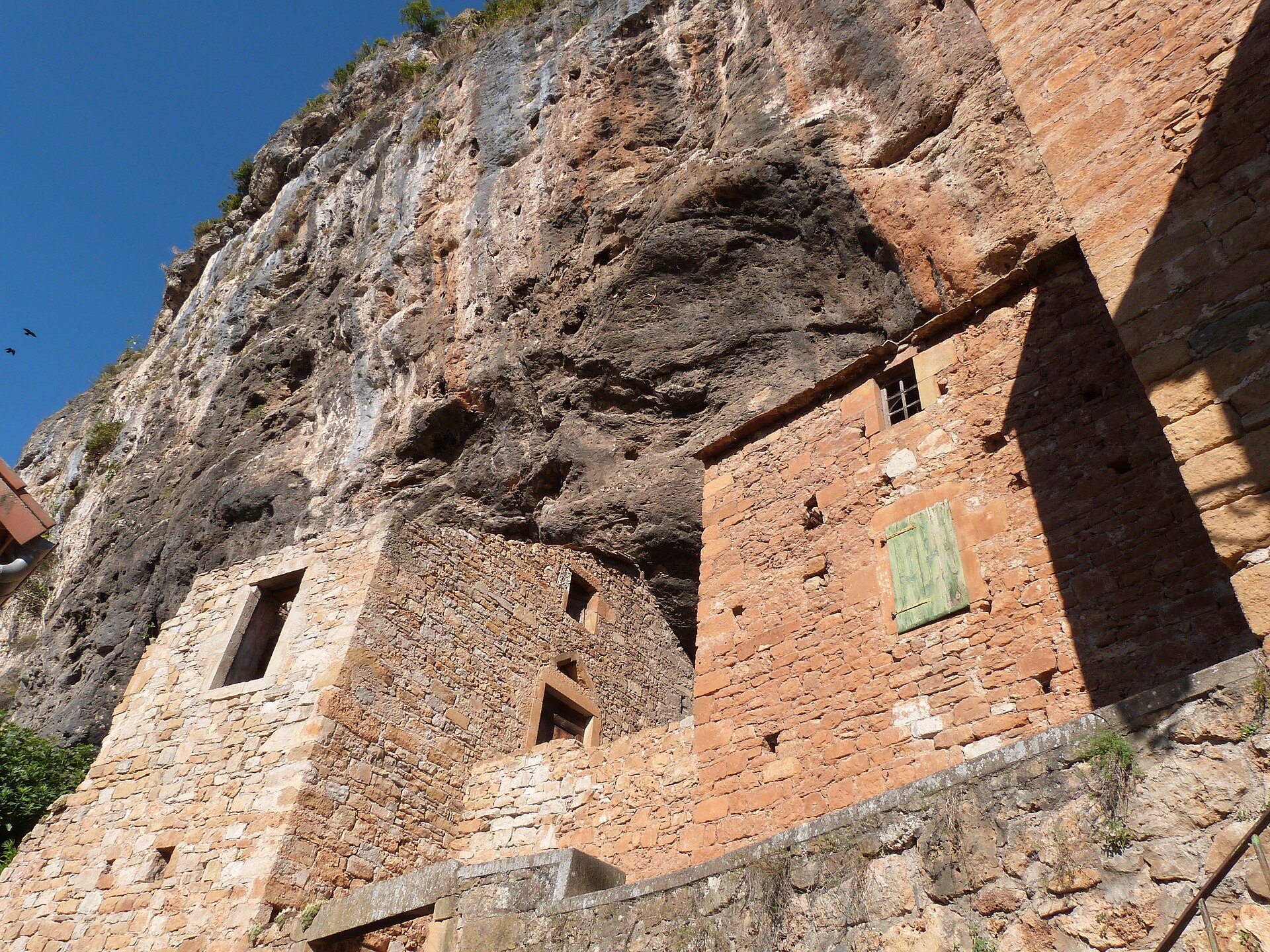 Maisons de pierre encastrées dans la falaise de tuf du village de Peyre